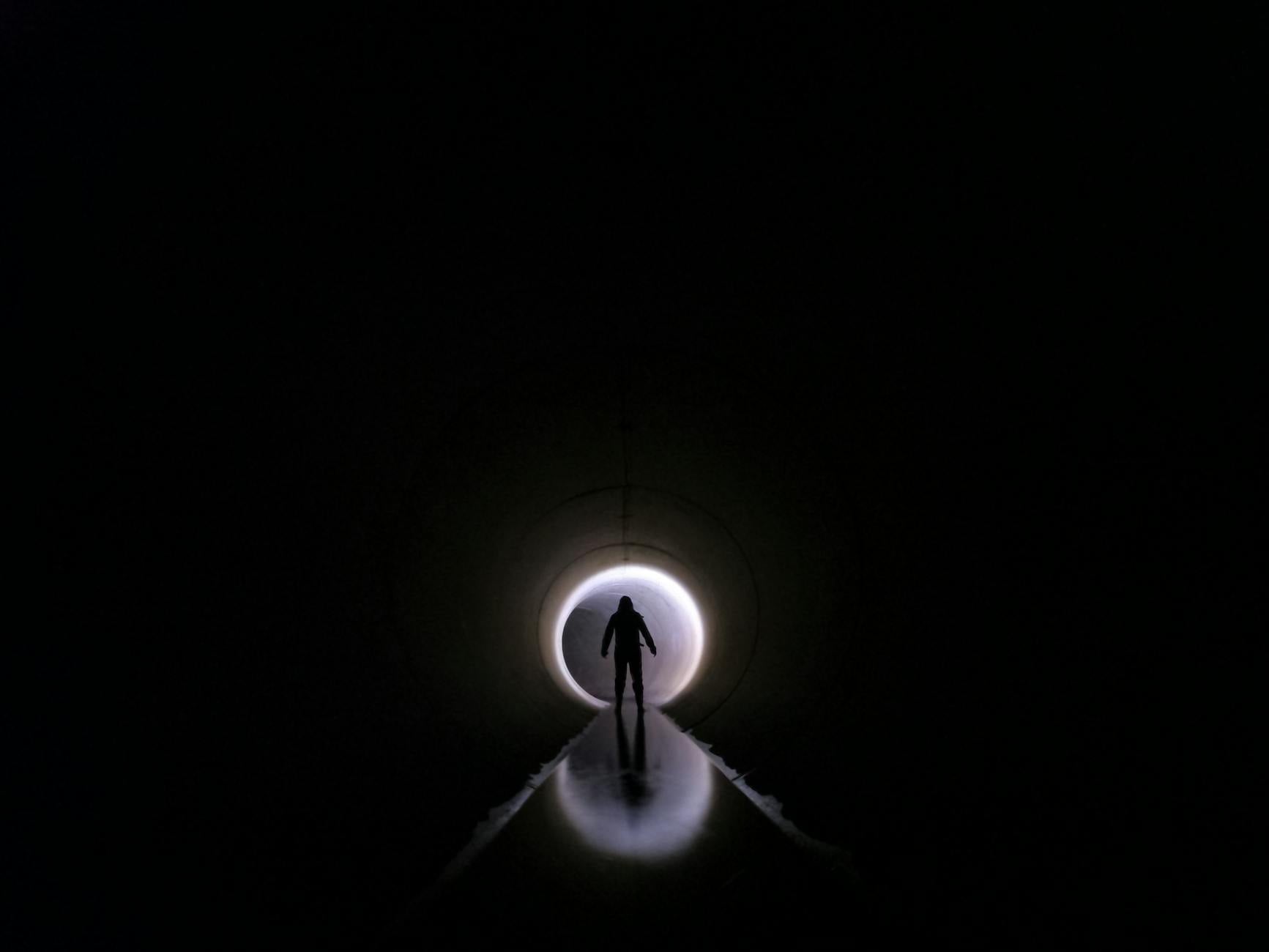 silhouette of man in tunnel