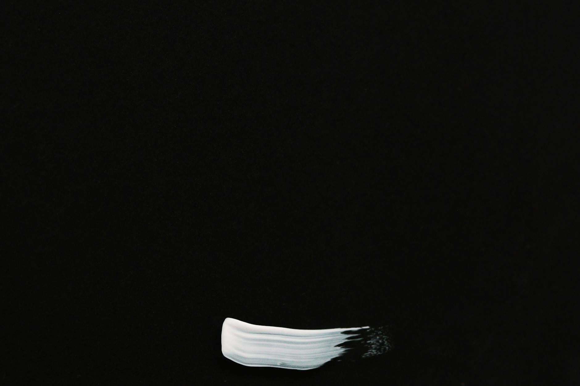 white paint smeared on a black background